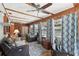 Bright living room with exposed beams, tile flooring, ceiling fans and lots of natural light at 31544 Wekiva River Trl, Sorrento, FL 32776