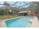 Beautiful backyard pool with an enclosed screen, landscaping, and view of the backyard at 31544 Wekiva River Trl, Sorrento, FL 32776