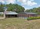 Backyard view featuring a screened pool, with surrounding trees at 31544 Wekiva River Trl, Sorrento, FL 32776