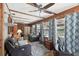 The sunroom features wood-paneled walls and ceiling beams with nice furniture at 31544 Wekiva River Trl, Sorrento, FL 32776