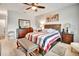 Well lit bedroom with comfortable bed, matching nightstands, a ceiling fan, and bench seat at 316 Nowell Loop, Deland, FL 32724