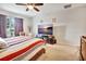 Bedroom with ceiling fan, large television, and neutral colored walls with elegant dark red curtains at 316 Nowell Loop, Deland, FL 32724