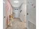 Inviting hallway with decorative columns, fresh flowers, artwork, and neutral tile flooring leading to the front door at 316 Nowell Loop, Deland, FL 32724
