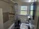 Bathroom features a tub, shower, and a classic vanity with a mirror and tiled walls at 317 Inwood Ave, New Smyrna Beach, FL 32168
