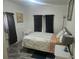 Cozy bedroom with an AC unit, wood-look floors, floral bedding and dark curtains at 317 Inwood Ave, New Smyrna Beach, FL 32168