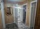 Hallway provides entry to bath with vinyl floor, decorative mirror, and floral decoration at 317 Inwood Ave, New Smyrna Beach, FL 32168