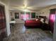 Spacious primary bedroom featuring wood-look floors and a large bed with red bedding at 317 Inwood Ave, New Smyrna Beach, FL 32168