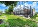 Landscaped backyard featuring a screened-in porch perfect for outdoor lounging and entertaining at 343 Lazio Cir, Debary, FL 32713