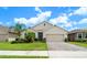 Lovely front exterior of this home featuring a brick driveway, lush green lawn, and mature trees at 343 Lazio Cir, Debary, FL 32713