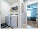 A laundry room features a modern washer and dryer set and a shelving unit at 343 Lazio Cir, Debary, FL 32713