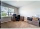 An office space has a wooden desk, rolling chair, storage cabinet, and natural light from a large window at 343 Lazio Cir, Debary, FL 32713