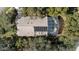 Aerial view of a house with a screened pool and solar panels amidst lush greenery at 3601 Galway Ln, Ormond Beach, FL 32174