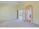 Cozy bedroom showcasing neutral tones, carpet flooring, an arched doorway, and a sliding glass door at 3601 Galway Ln, Ormond Beach, FL 32174
