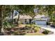 Front exterior view of the house with mature landscaping, trees, and an attached two-car garage at 3601 Galway Ln, Ormond Beach, FL 32174