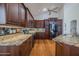 Gourmet kitchen featuring granite countertops, wooden cabinets, stainless steel appliances, and wood floor at 3601 Galway Ln, Ormond Beach, FL 32174