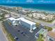 An aerial view of the condo building with many parking spots located close to the beautiful beaches of sunny Florida at 3700 S Atlantic Ave # 413, New Smyrna Beach, FL 32169