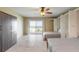 This bedroom features two beds, closet, tile flooring, ceiling fan, and sliding door to the exterior balcony and ocean views at 3700 S Atlantic Ave # 413, New Smyrna Beach, FL 32169