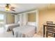 This bedroom features two beds, tile flooring, ceiling fan, and sliding door to the exterior balcony and ocean views at 3700 S Atlantic Ave # 413, New Smyrna Beach, FL 32169