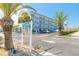 Exterior shot of Mariner's Cove building, featuring palm trees and ample parking at 3700 S Atlantic Ave # 413, New Smyrna Beach, FL 32169