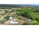 Aerial shot featuring a property with lush landscaping, a pond, and nearby structures at 4145 Rambler Ave, St Cloud, FL 34772