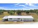 Aerial view of large building with a metal roof and surrounding green fields at 4145 Rambler Ave, St Cloud, FL 34772