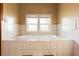 Bright bathroom features a tiled soaking tub under two windows for relaxation at 4145 Rambler Ave, St Cloud, FL 34772