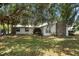 Charming single-story home featuring a stone chimney and a lush front yard with mature trees draped in Spanish moss at 4145 Rambler Ave, St Cloud, FL 34772