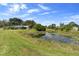 Scenic view of a pond with lily pads on a sunny day, adjacent to a house with a screened-in enclosure at 4145 Rambler Ave, St Cloud, FL 34772