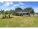View of screened-in pool enclosure in a large backyard featuring lush greenery and banana trees at 4145 Rambler Ave, St Cloud, FL 34772