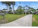Well-maintained home with a lush green lawn, mature trees, and a long driveway at 44 Fairway Cir, New Smyrna Beach, FL 32168