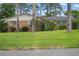 Charming home with a lush green lawn, mature trees, and well-maintained landscaping at 44 Fairway Cir, New Smyrna Beach, FL 32168