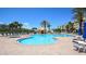 Relaxing community pool area with lounge chairs, palm trees, and a gazebo at 4670 Links Village Dr # A506, Ponce Inlet, FL 32127