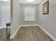 Small room with gray wood-look flooring, neutral paint, and large window at 4670 Links Village Dr # A506, Ponce Inlet, FL 32127