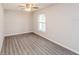 Bright bedroom with gray wood floors, a ceiling fan, and a large window at 495 6Th St, Holly Hill, FL 32117