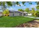 Side view of a single story home with green grass in the front yard and a long driveway at 495 6Th St, Holly Hill, FL 32117