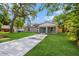 Charming single-story home with a well-manicured lawn, long driveway and a blue front door at 495 6Th St, Holly Hill, FL 32117