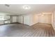 Spacious living room with gray wood floors and easy access to kitchen at 495 6Th St, Holly Hill, FL 32117