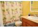 Bathroom with yellow walls, neutral shower curtain, and neutral vanity at 522 Grace Ave, Deland, FL 32724