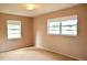 Neutral bedroom with two windows allowing natural light and neutral carpeting at 522 Grace Ave, Deland, FL 32724