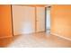 Bedroom with orange walls, closet with white sliding doors and white trim throughout at 522 Grace Ave, Deland, FL 32724