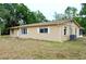 A single story home with a tan facade, white trimmed windows, and an open yard at 522 Grace Ave, Deland, FL 32724