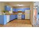 A kitchen with wooden floors, blue cabinets, and white appliances at 522 Grace Ave, Deland, FL 32724