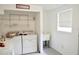 Functional laundry room with washer, dryer, utility sink, and shelving at 522 Grace Ave, Deland, FL 32724