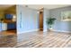 Open-concept living room featuring wood floors, a blue accent wall, and a view to the kitchen at 522 Grace Ave, Deland, FL 32724