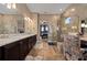 Bathroom featuring dual sinks, wood cabinets, glass shower with a decorative chair and wood tile floors at 5430 Nw 35Th Lane Rd, Ocala, FL 34482