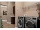 The laundry room has a front load washer and dryer, a shelf above, and a dark cabinet at 5430 Nw 35Th Lane Rd, Ocala, FL 34482
