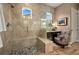 This bathroom has a glass shower with a pebble floor, a vanity area, and lots of tile at 5430 Nw 35Th Lane Rd, Ocala, FL 34482