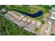Overhead shot of condo complex featuring a pool, parking, and serene pond surrounded by lush greenery at 576 Belltower Ave # 100, Deltona, FL 32725