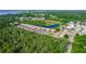 Aerial view of the condo complex near the water with lush landscaping, parking, and a serene pond at 576 Belltower Ave # 100, Deltona, FL 32725