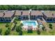 Aerial view showcasing a community pool, clubhouse, and nearby condos surrounded by vibrant landscaping at 576 Belltower Ave # 100, Deltona, FL 32725